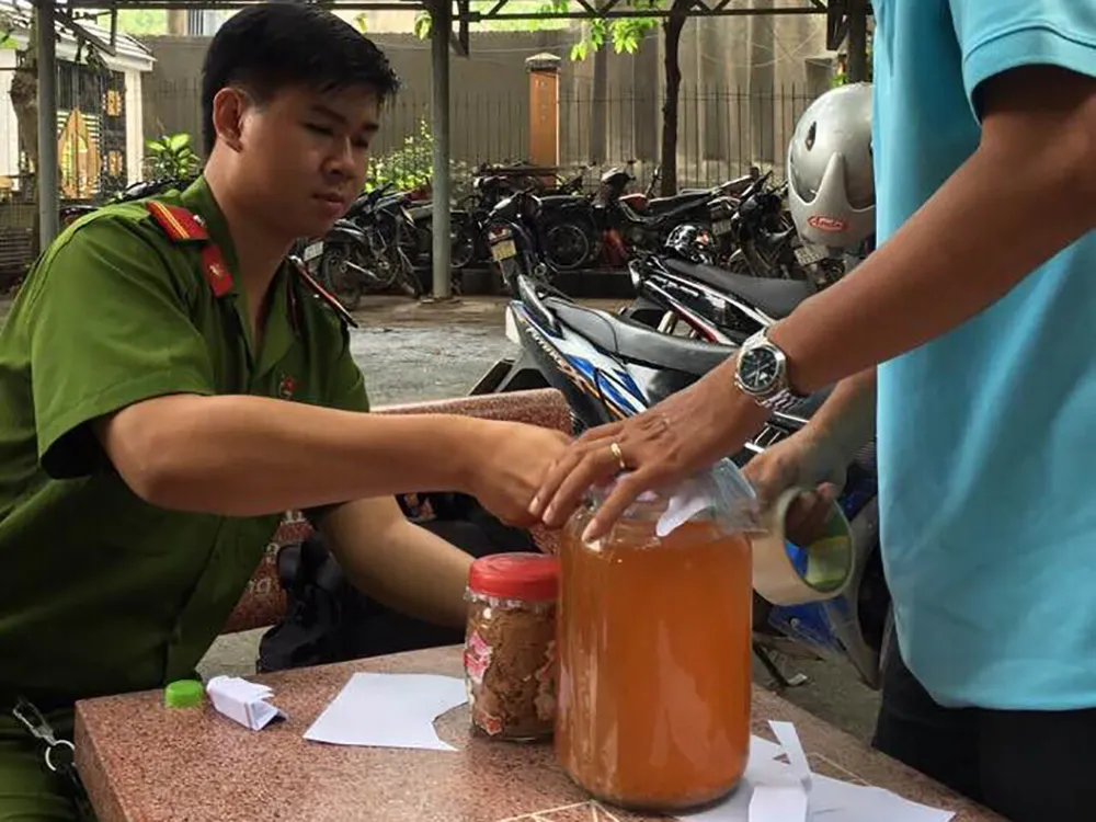 Công an tiến hành lấy mẫu giám định chất độc trong nước lèo dùng để nấu bún